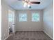 Bedroom with gray carpet and neutral walls, featuring two windows and an ensuite bathroom at 4230 Cheryl Ann Ct, Stone Mountain, GA 30083
