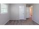 This bedroom has neutral walls and carpeted floors, with a window and an open door at 4230 Cheryl Ann Ct, Stone Mountain, GA 30083