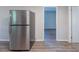 Stainless steel refrigerator and a glimpse into another room featuring neutral paint and wood flooring at 4230 Cheryl Ann Ct, Stone Mountain, GA 30083