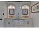 Bright bathroom featuring double sinks, granite countertops, custom cabinetry and a decorative mirror at 5105 Vernon Oaks Dr, Dunwoody, GA 30338