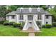 Charming two-story home with symmetrical design, landscaped yard, and double staircase leading to the front entrance at 5105 Vernon Oaks Dr, Dunwoody, GA 30338