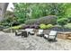Stone patio area with outdoor seating and manicured landscaping, perfect for entertaining at 5105 Vernon Oaks Dr, Dunwoody, GA 30338