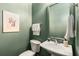 Well-maintained half bathroom featuring a pedestal sink, toilet, and green painted walls at 616 Angier Ne Ave # 4, Atlanta, GA 30308