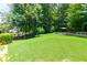 Expansive backyard featuring a lush lawn, mature trees, and a charming patio area at 650 Chestatee Creek Nw Dr, Acworth, GA 30101