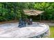 Backyard patio featuring stone pavers, wood chairs, umbrella and firepit; perfect for gatherings and outdoor enjoyment at 650 Chestatee Creek Nw Dr, Acworth, GA 30101