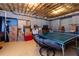 Basement rec room featuring ping pong table, storage boxes, exposed ceiling, and painted concrete flooring at 650 Chestatee Creek Nw Dr, Acworth, GA 30101