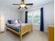 Bright bedroom with neutral carpet, a ceiling fan, large window, and a light colored wooden bed frame at 650 Chestatee Creek Nw Dr, Acworth, GA 30101