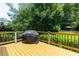 Serene deck with wooden railing, a grill, and wooded backyard view at 650 Chestatee Creek Nw Dr, Acworth, GA 30101