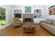 Inviting living room featuring a stone fireplace, hardwood floors, built-in shelves, and natural light at 650 Chestatee Creek Nw Dr, Acworth, GA 30101