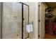 Main bathroom shower featuring glass door, stone tile surround, and adjacent walk-in closet at 650 Chestatee Creek Nw Dr, Acworth, GA 30101