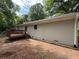 Back of a white painted brick home featuring a stained deck and wooded backyard at 2943 Westbury Dr, Decatur, GA 30033