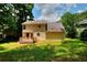 Exterior rear view of house with wooden deck, level grassy yard and trees at 2983 Trotters View Way, Snellville, GA 30039