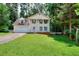 Charming two-story home featuring a well-manicured lawn, two-car garage, and mature trees at 2983 Trotters View Way, Snellville, GA 30039