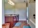 Bathroom with wood cabinets, large mirror, wood flooring, tub and tile surround at 609 Turnbill Dr, Mcdonough, GA 30252