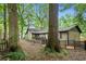 Backyard with green perimeter featuring mature trees and a small wooden deck with black railings at 778 Mclendon Dr, Decatur, GA 30079