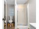 Small bathroom with a toilet, frosted glass shower stall, and a small window with blinds at 778 Mclendon Dr, Decatur, GA 30079