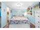 Cozy bedroom featuring light blue walls, window decor, and a comfortable-looking bed with a floral pattern at 778 Mclendon Dr, Decatur, GA 30079