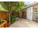 Enclosed backyard with wooden fence and patio featuring beautiful greenery, stone pavers, and a side entry door at 104 Powell Cv, Decatur, GA 30030