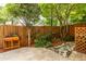 Fenced backyard featuring lush greenery, stone pavers, mulched planting beds, and a wooden flower box at 104 Powell Cv, Decatur, GA 30030