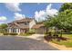 View of a two-story townhome with an attached garage, surrounded by a green lawn, trees and paved driveways at 104 Powell Cv, Decatur, GA 30030