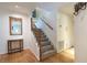 Open hallway showcasing wood floors and a carpeted staircase, with a decorative table adding character at 104 Powell Cv, Decatur, GA 30030