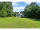 Backyard view of home, featuring a spacious lawn and mature trees at 1213 Grande Vw, Loganville, GA 30052