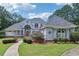 Stunning home featuring a manicured lawn, inviting walkway, and a unique architectural design with arched windows and a stately entrance at 1213 Grande Vw, Loganville, GA 30052