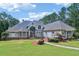 Imposing facade of a luxury home, featuring a manicured lawn, inviting walkway, and a unique architectural design at 1213 Grande Vw, Loganville, GA 30052