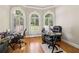 Home office with hardwood floors and three arched windows providing natural light at 1213 Grande Vw, Loganville, GA 30052