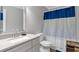 Bathroom featuring a single sink vanity, a toilet, and a white and blue shower curtain at 155 N Fayette Dr, Fayetteville, GA 30214