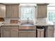 Well-lit kitchen featuring a stainless steel sink, granite countertops, and custom cabinets at 155 N Fayette Dr, Fayetteville, GA 30214