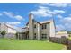 Back exterior view showcases a well-maintained lawn and a covered patio with a charming fire pit at 229 Traditions Drive Southeast Dr, Loganville, GA 30052