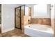Modern bathroom with a glass-enclosed shower, soaking tub, and tiled walls at 229 Traditions Drive Southeast Dr, Loganville, GA 30052