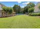 Beautifully manicured backyard featuring a lush green lawn and mature trees with a seating area at 7325 Brookwood Way, Cumming, GA 30041