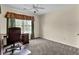 Bedroom with a large window, fan, and a cozy study corner with a wooden desk and chair at 7325 Brookwood Way, Cumming, GA 30041