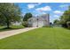 Well-kept two-story home with a spacious lawn, mature trees, and a driveway leading to the garage at 7325 Brookwood Way, Cumming, GA 30041