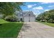 Inviting home with a manicured lawn, mature trees, and a long driveway leading to a two-car garage at 7325 Brookwood Way, Cumming, GA 30041