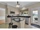 Functional kitchen with a central island, black countertops, and a view to the backyard through a large window at 7325 Brookwood Way, Cumming, GA 30041