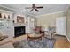 Inviting living room with fireplace, built-in shelving, ceiling fan, and plush seating area at 7325 Brookwood Way, Cumming, GA 30041