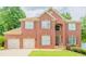 Beautiful two-story brick home featuring a manicured lawn and a three car garage at 10950 Glenhurst, Duluth, GA 30097