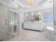 Luxurious bathroom with a walk-in shower, double vanity, soaking tub, and elegant lighting at 605 Linkside Hollow, Alpharetta, GA 30005