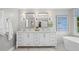Bright bathroom featuring a double vanity, dual mirrors, and a large soaking tub at 605 Linkside Hollow, Alpharetta, GA 30005