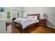 Spacious primary bedroom with hardwood floors, a tray ceiling, and a large window overlooking the backyard at 605 Linkside Hollow, Alpharetta, GA 30005