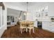 Open dining area with hardwood floors, modern lighting, white cabinetry, and wine fridge at 605 Linkside Hollow, Alpharetta, GA 30005