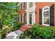 Traditional red brick home with black shutters and meticulously landscaped front yard at 605 Linkside Hollow, Alpharetta, GA 30005