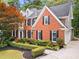 Two-story red brick home with manicured lawn and dark shutters at 605 Linkside Hollow, Alpharetta, GA 30005