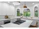 Modern kitchen design with quartz counters, stainless appliances, and arched windows offering wooded views at 605 Linkside Hollow, Alpharetta, GA 30005