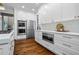 Modern kitchen features stainless steel appliances, white cabinets, and ample counter space for cooking at 605 Linkside Hollow, Alpharetta, GA 30005