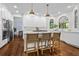 Beautiful white kitchen with island seating, stainless steel appliances, quartz counters, and modern lighting at 605 Linkside Hollow, Alpharetta, GA 30005