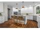 Bright, remodeled kitchen features a quartz countertop island, pendant lighting, and stainless steel appliances at 605 Linkside Hollow, Alpharetta, GA 30005